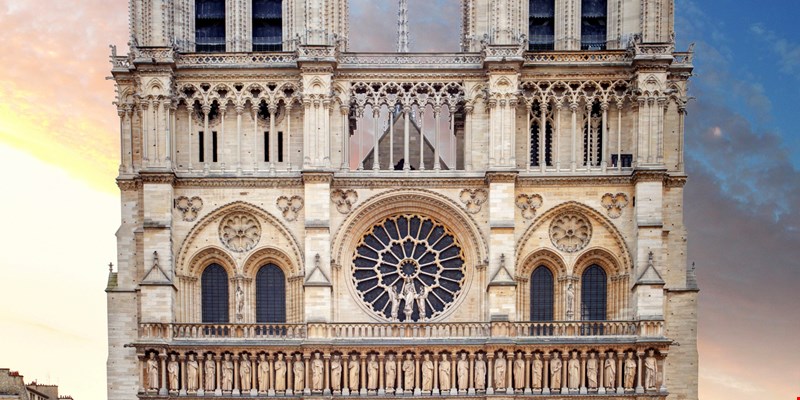 Front view of illuminated Notre Dame De Paris cathedral day to night transition timelapse after sunset. Colorful sky on a background. Paris, France, Europe. View from Cardinal Lustiger bridge.